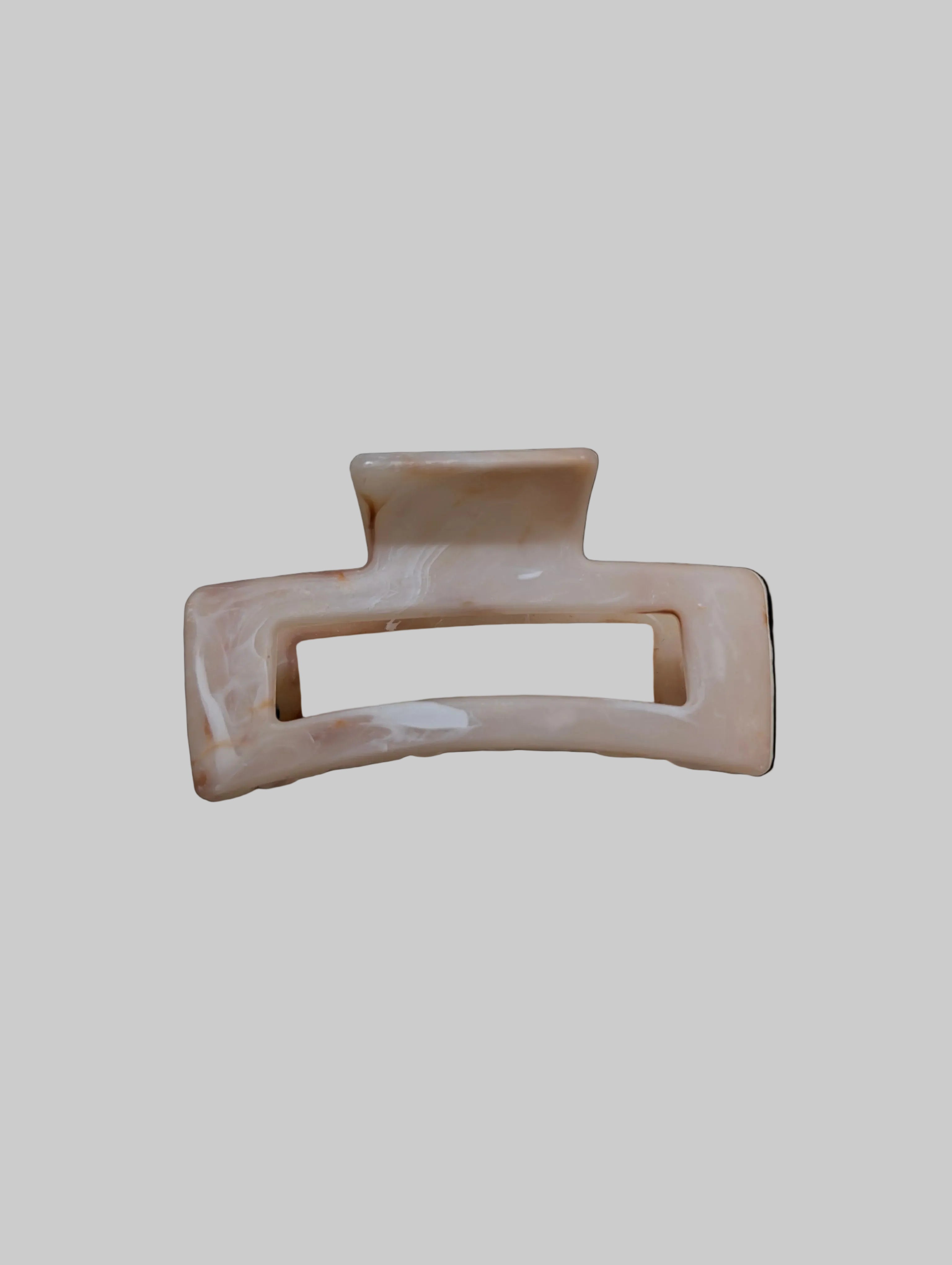Beige hair clip on a light beige background
